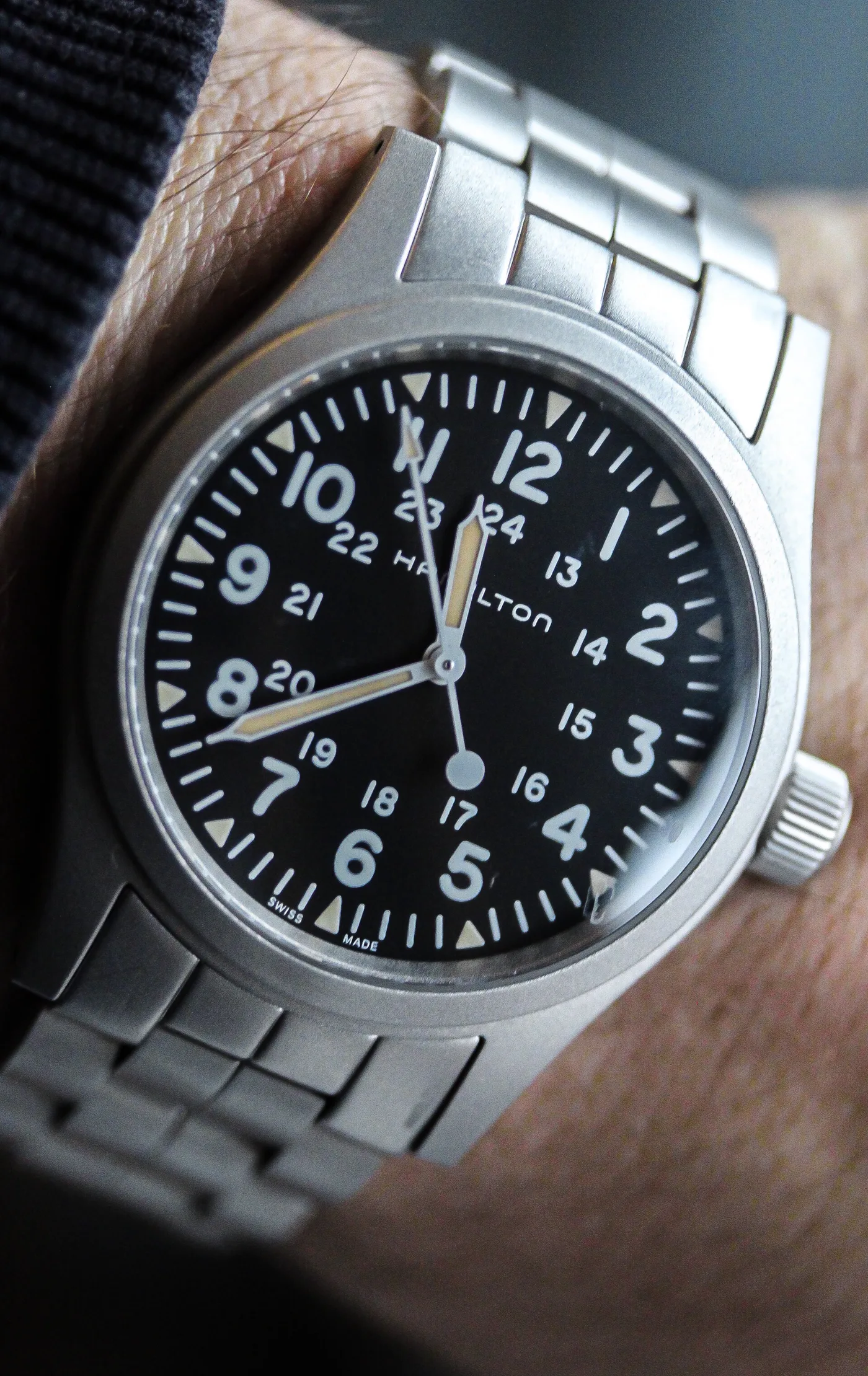Hamilton Khaki Field Mechanical watch with black dial worn on wrist with steel bracelet